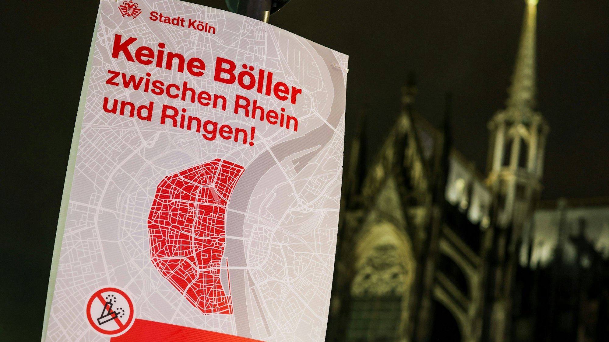 Ein Plakat der Stadt Köln zum Böllerverbot mit der Aufschrift K„eine Böller zwischen Rhein und Ringen!“ hängt in der Nähe des Kölner Doms.