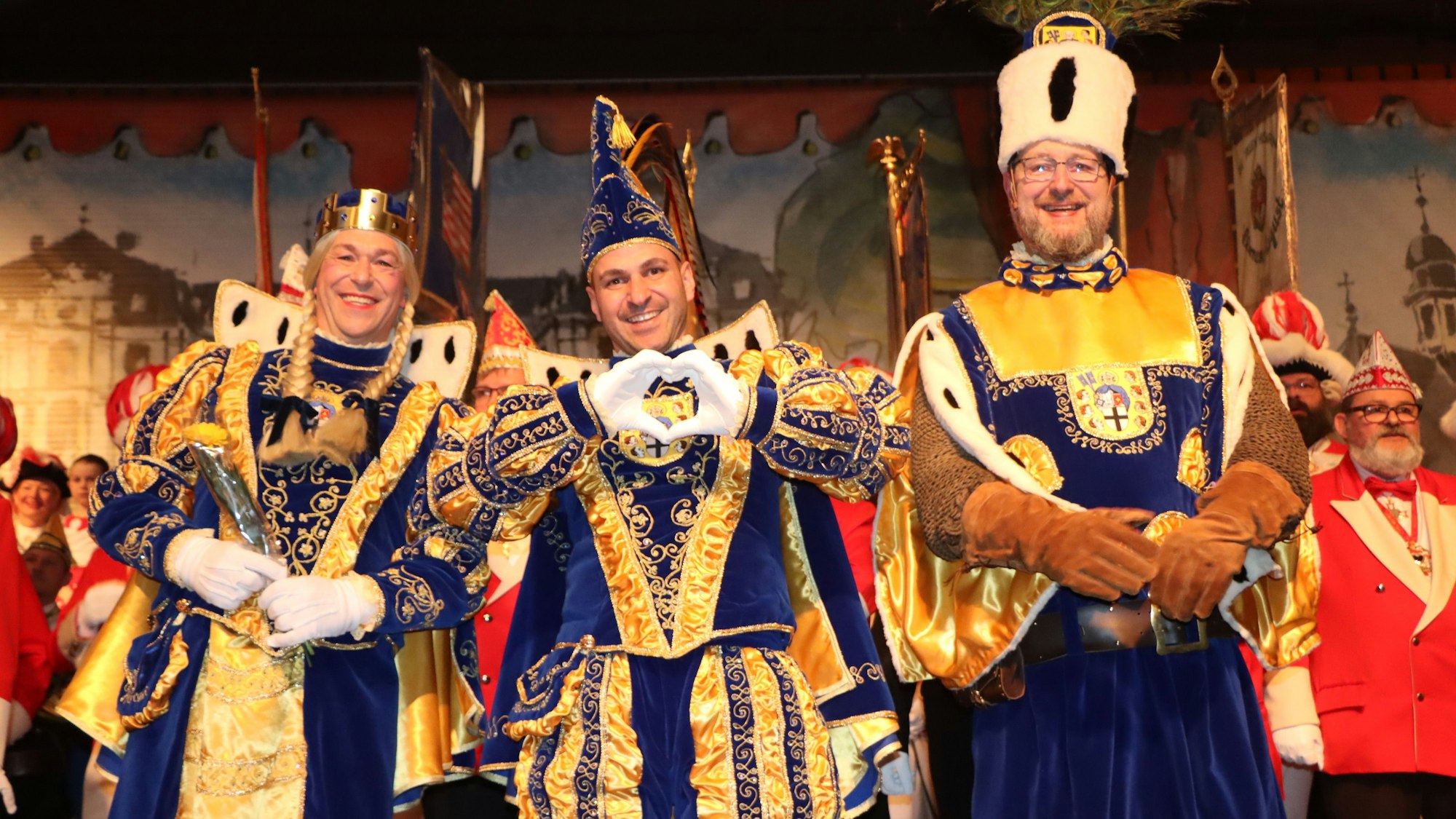 Das Foto zeigt das Brühler Dreigestirn auf der Bühne.