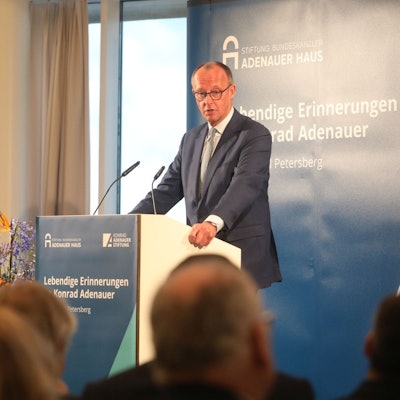 Auf Einladung der Kontrad-Adenauer-Stiftung sprach Friedrich Merz auf dem Petersberg: Ein großer Mann im Anzug steht an einem Rednerpult.