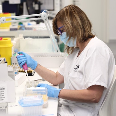 Eine Frau mit Gesichtsmaske arbeitet in einem Labor.