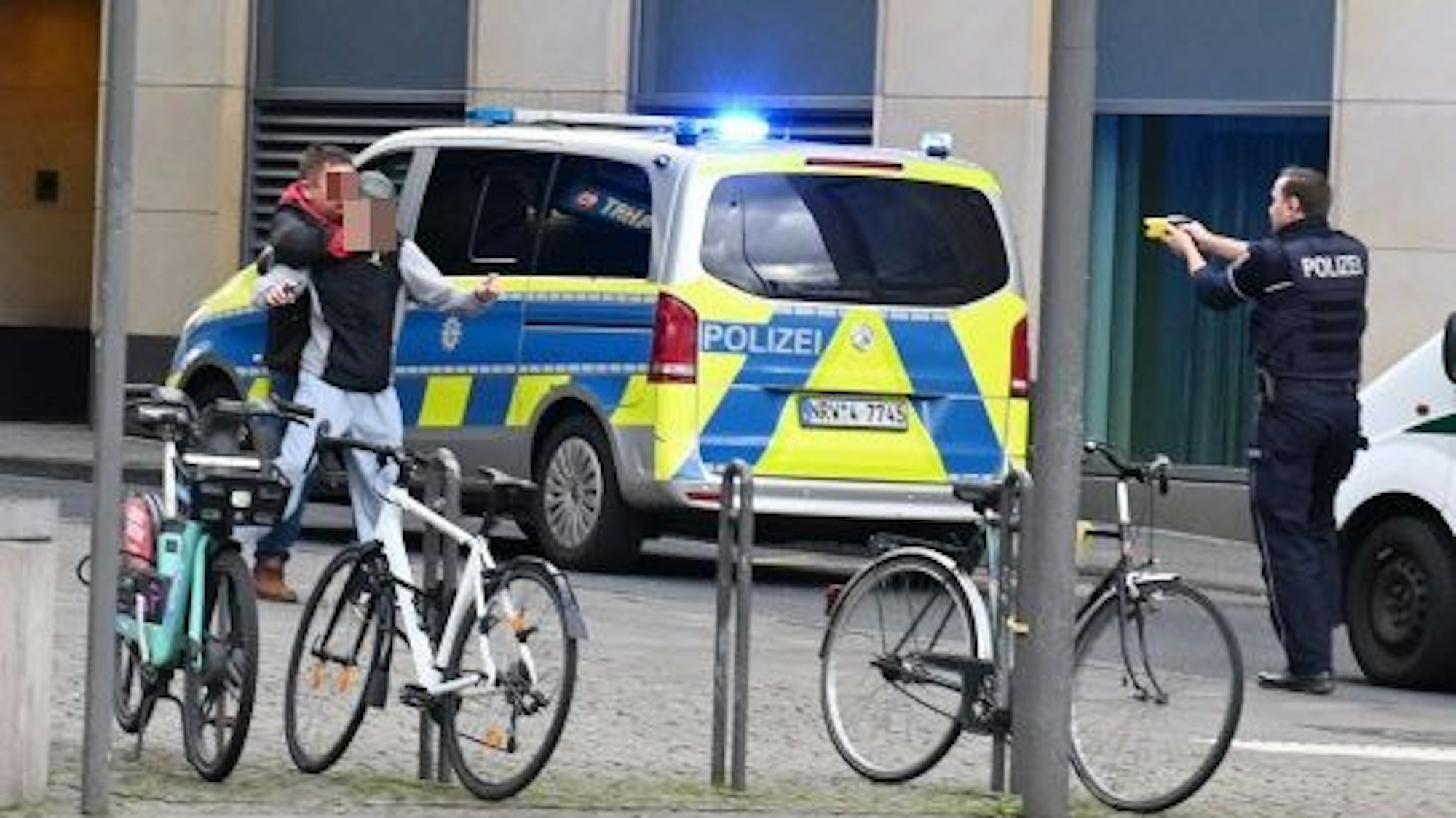 Ein Mann bedroht einen Jugendlichen. Ein Polizist zielt mit seinem Taser auf den 42-Jährigen.