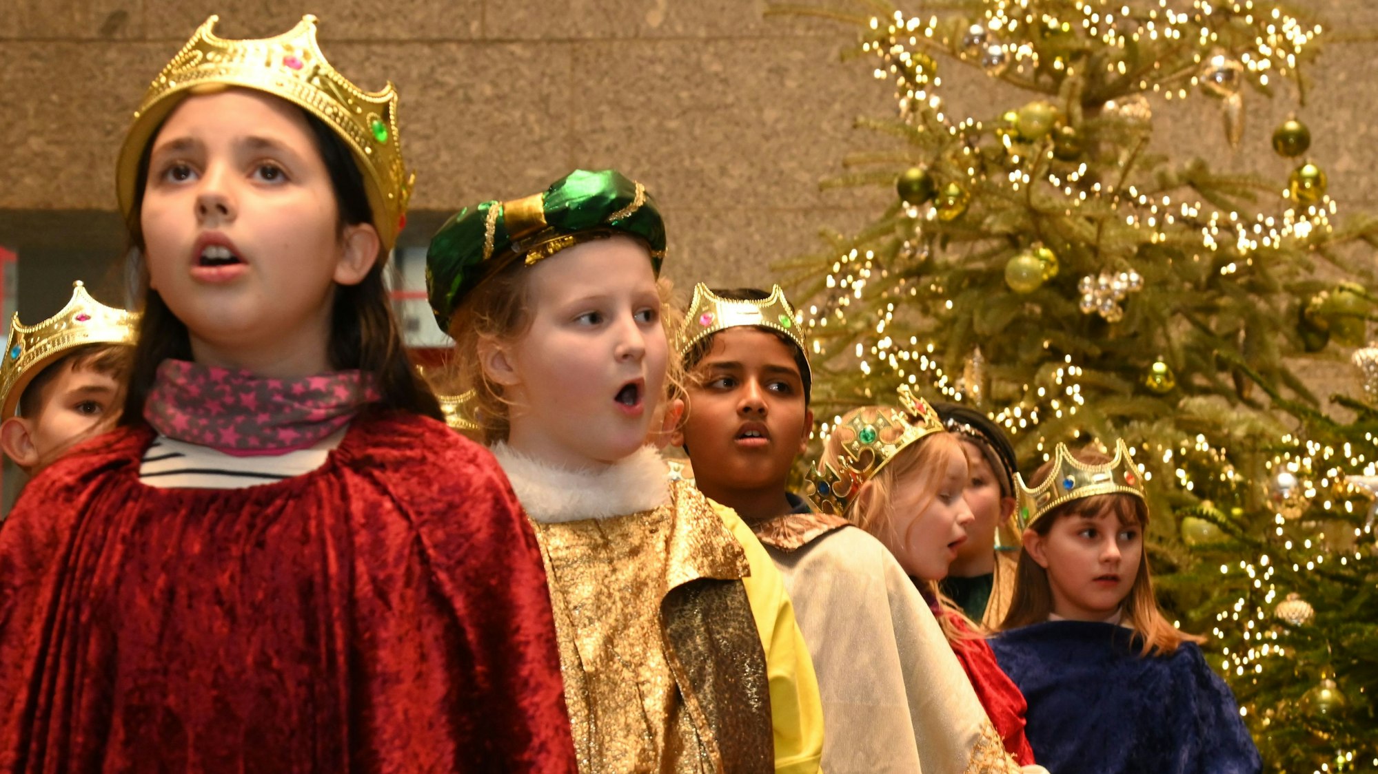 Zu sehen sind mehrere singende Kinder im Sternsingergewand.