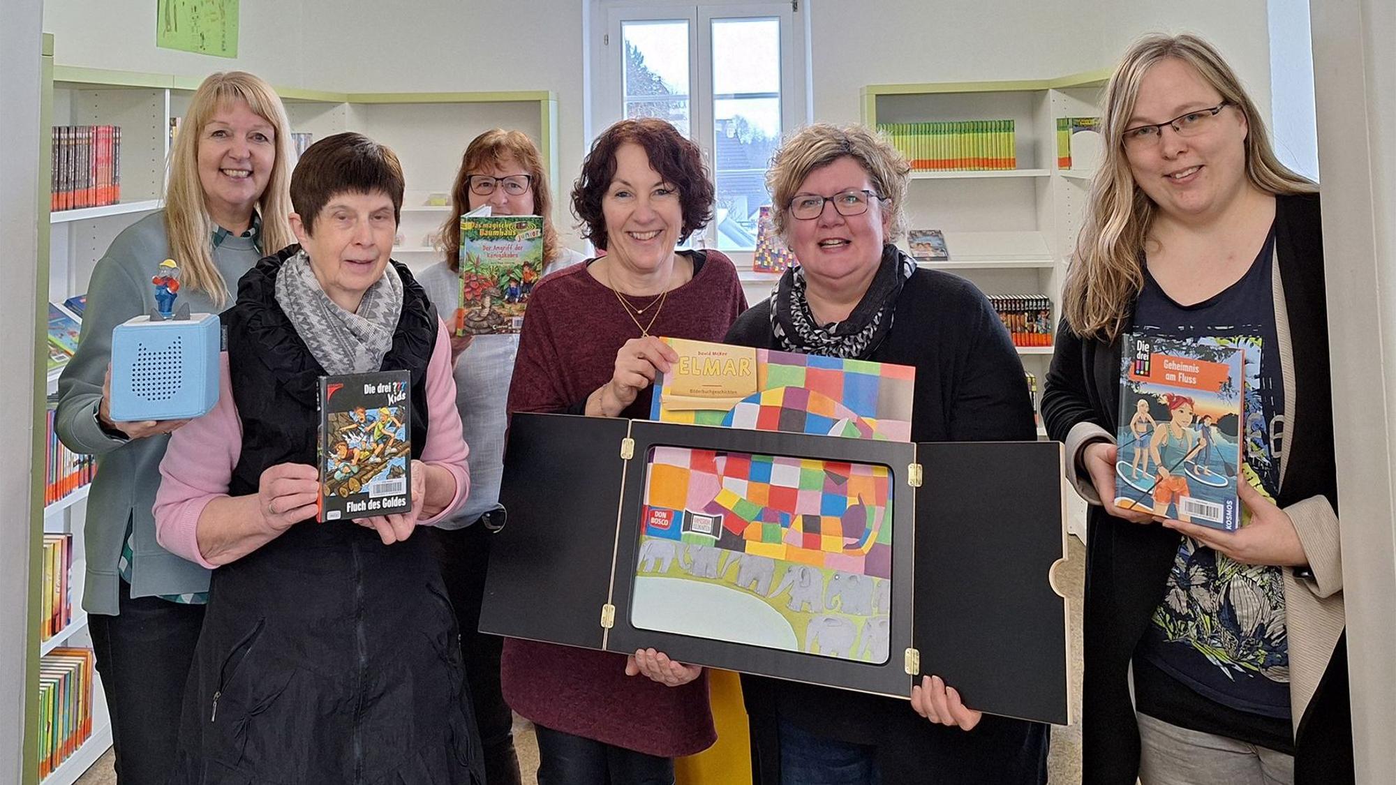 Doris Hilger, Irmgard Manderfeld, Silvia Müller, Andrea Niebes, Judith Keuer und Ingrid Koll zeigen Bücher und Spiele.