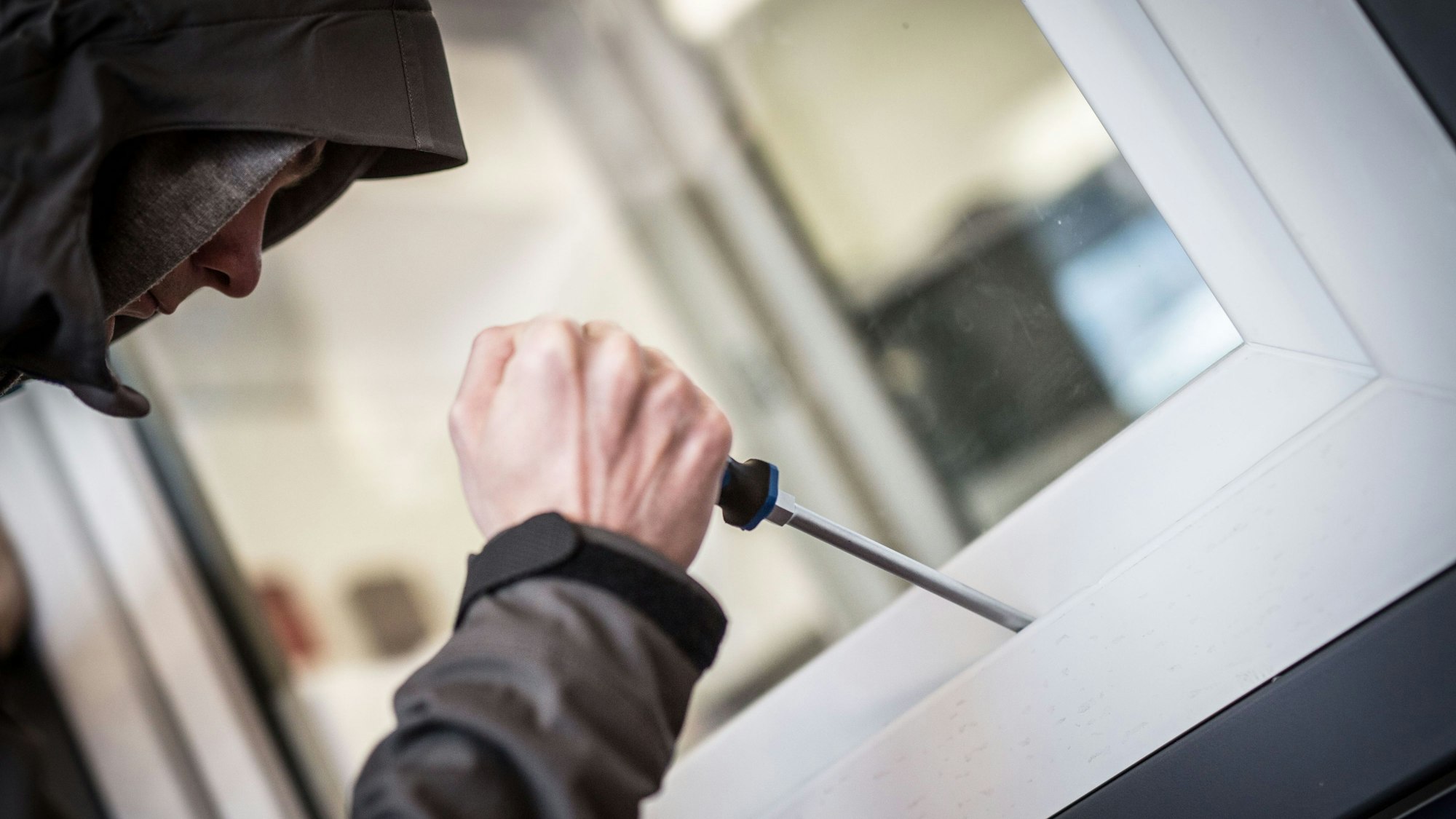 Ein Mann demonstriert in der polizeilichen Beratungsstelle, wie Einbrecher Fenster aufhebeln.