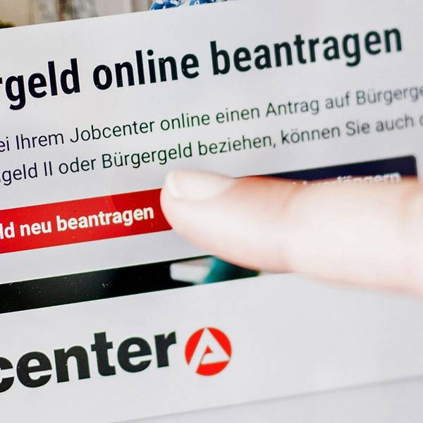 Eine Frau tippt auf einem Tablet auf einen Link zum Beantragen des Bürgergeldes im Kundenbereich im Jobcenter Berlin Mitte.