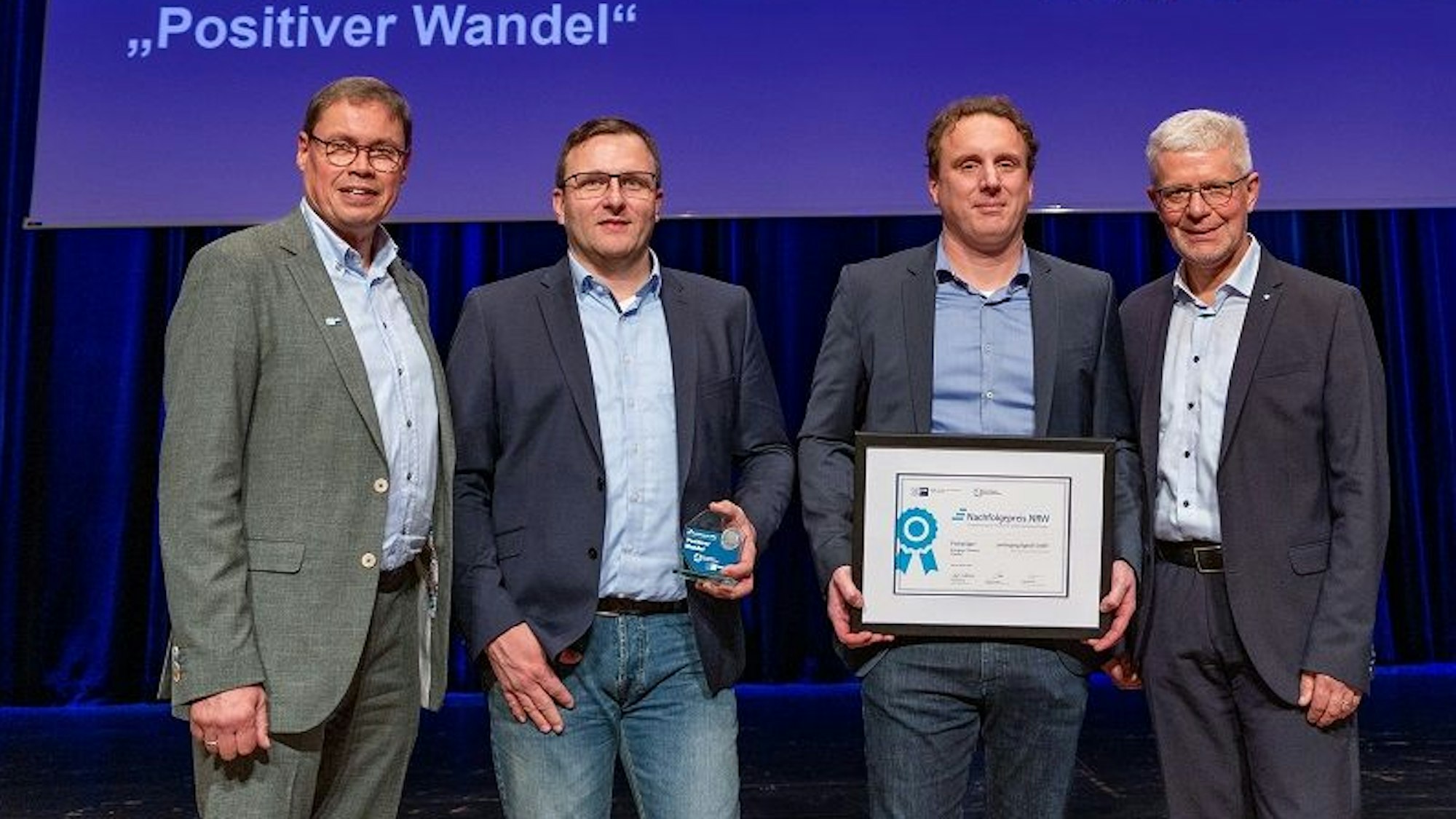 Ralf Stoffels (v.l.), Sebastian Wolff, Mario Deilen präsentieren die Urkunde, daneben steht Manfred Thivessen, Geschäftsführer der Bürgschaftsbank NRW.