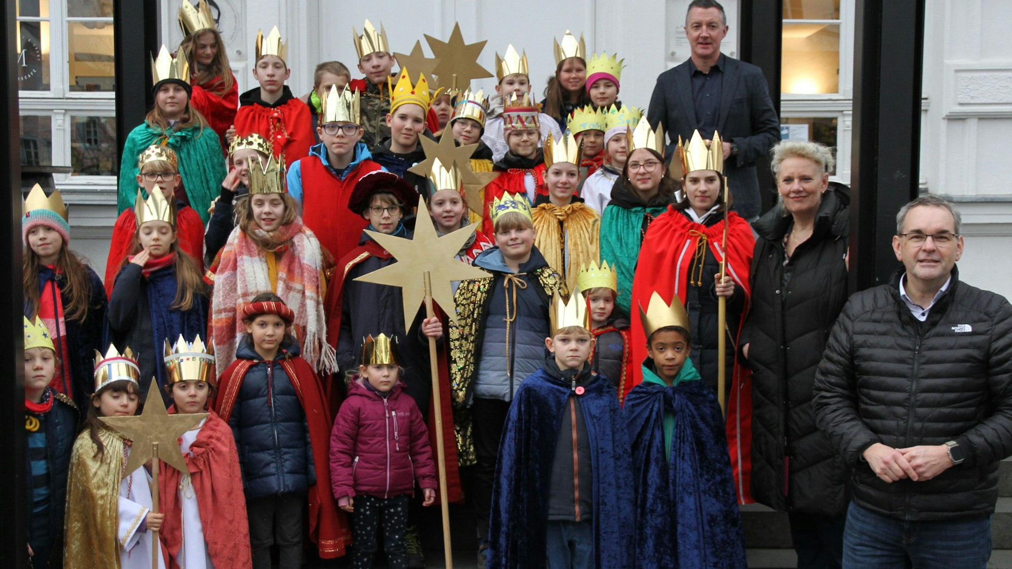 Eine Gruppe von 30 Sternsingern und drei Erwachsenen auf der Treppe eines Museums.