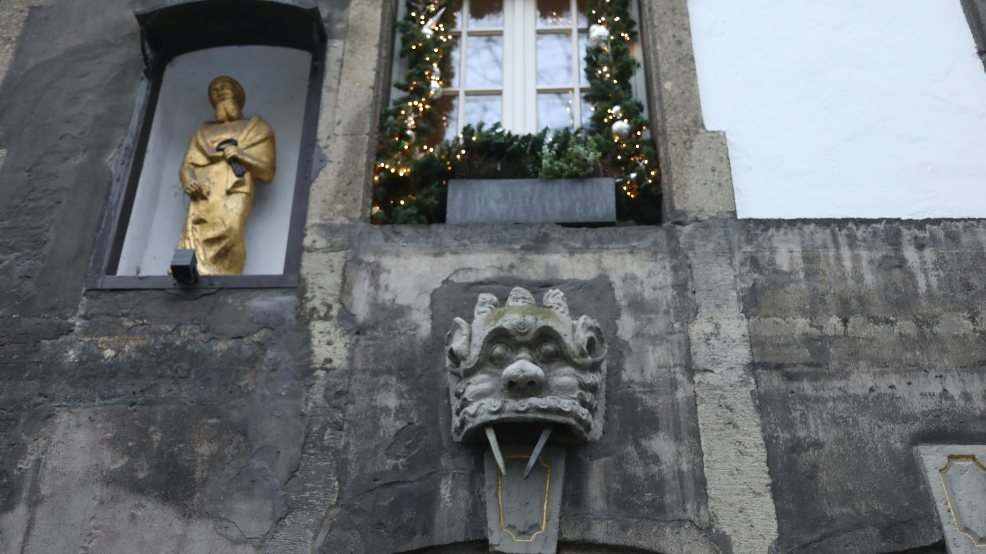 Fotos von Grinköpfen (groteske, steinerne Fratzenmasken), die man an vielen Hausfassaden in der Altstadt sieht.