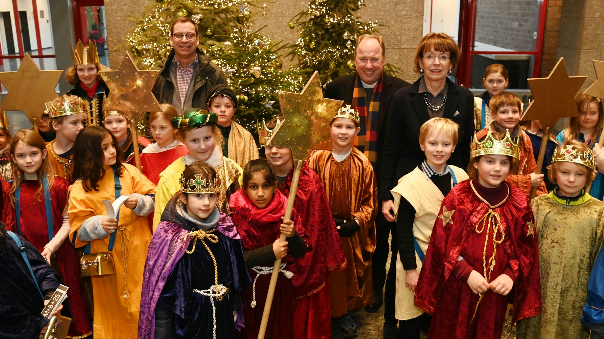 Zu sehen sind mehrere Kinder im Sternsingergewand, sowie Burkard Hofer, Monsignore Robert Kleine und Henriette Reker.
