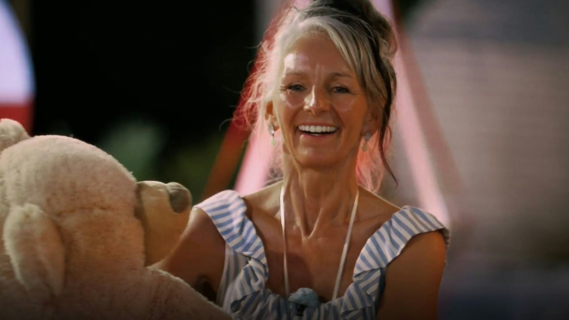 Die 62-jährige Sabine aus Troisdorf verpasste nur um Haaresbreite die Top drei bei der RTL-Datingshow „Golden Bachelor“. Hier hält sie einen riesigen Teddybären in den Armen und lacht in Richtung Kamera.