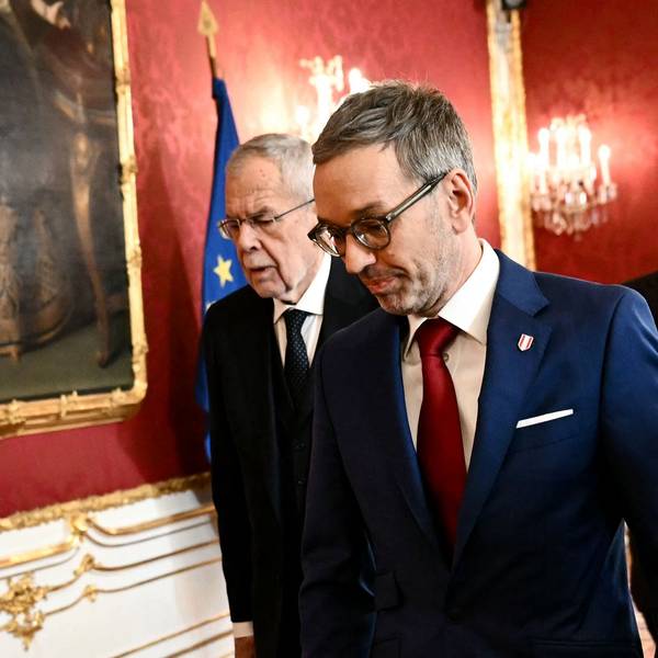 Alexander Van der Bellen und Herbert Kickl gehen eine Wand mit Österreich-Flagge entlang.