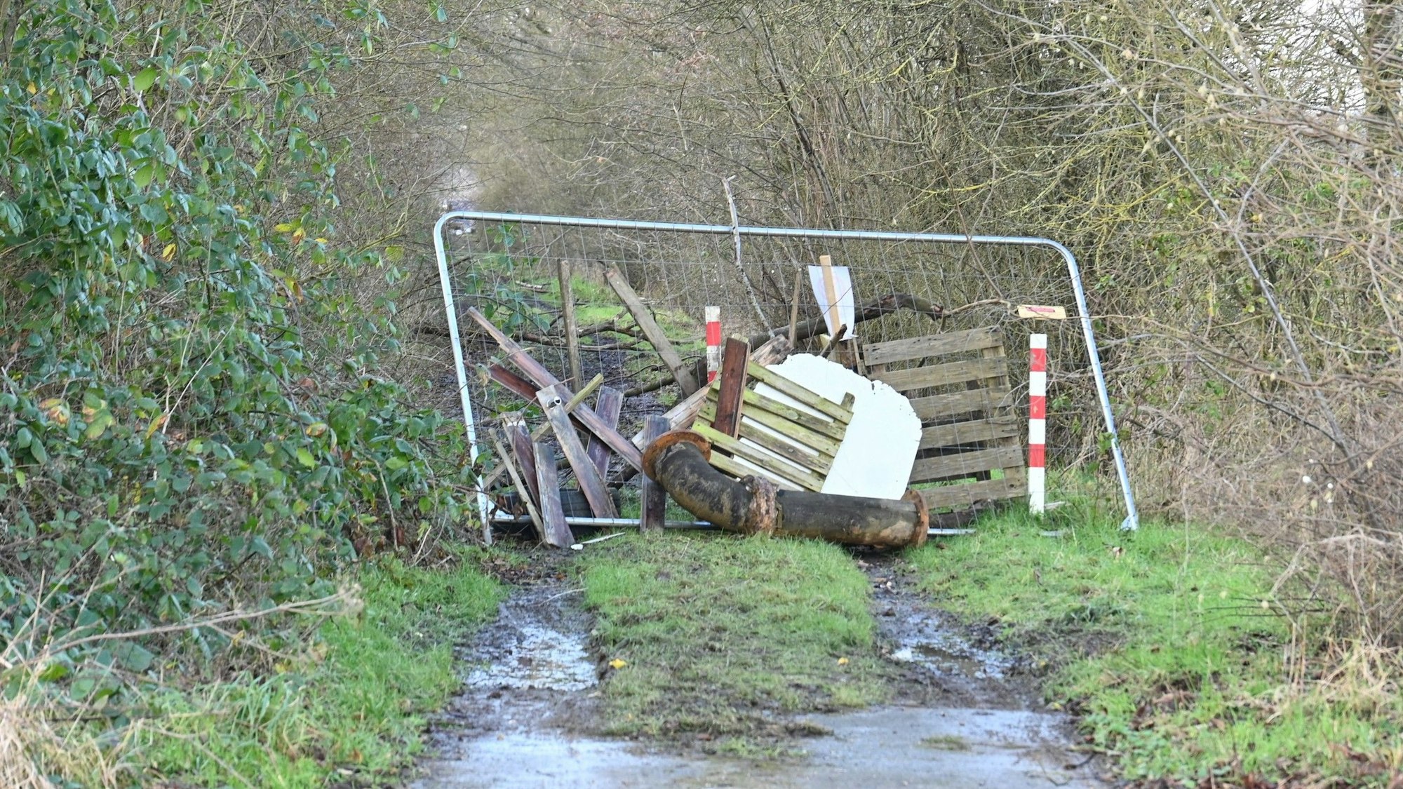 Das Bild zeigt einen zugestellten Feldweg