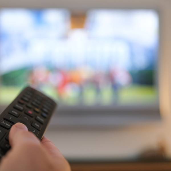Eine Hand bedient eine Fernbedienung für ein TV-Gerät (Archivbild).