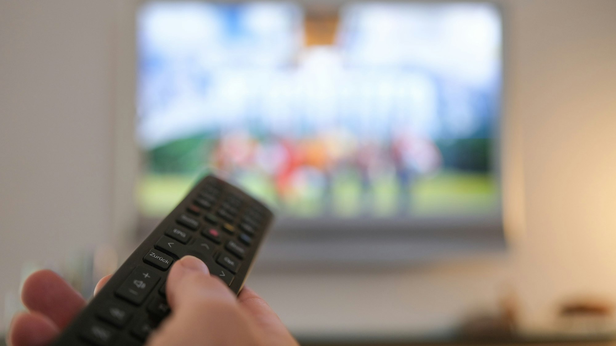 Eine Hand bedient eine Fernbedienung für ein TV-Gerät (Archivbild).