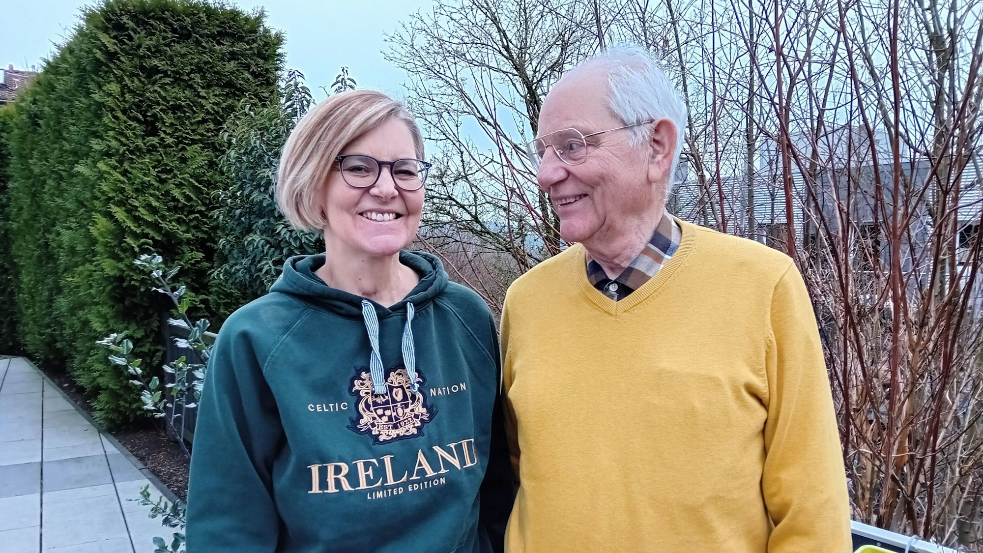 Ein älterer Herr blickt auf eine jüngere Frau.