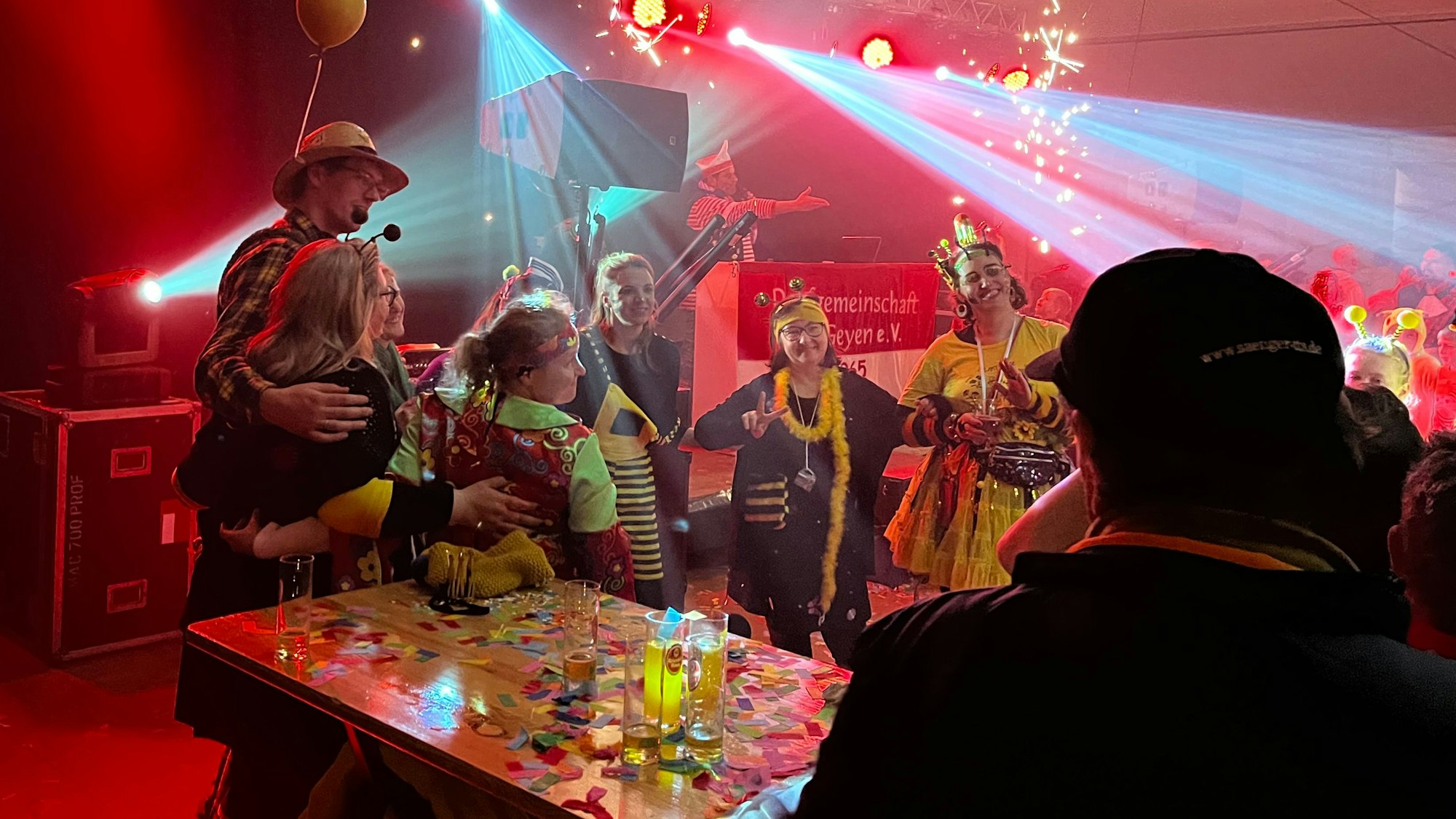 Kostümierte Frauen und Männer feiern in einem Zelt.