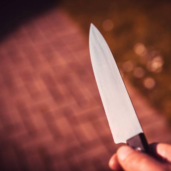 Eine Männerhand mit Messer.