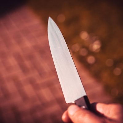 Eine Männerhand mit Messer.