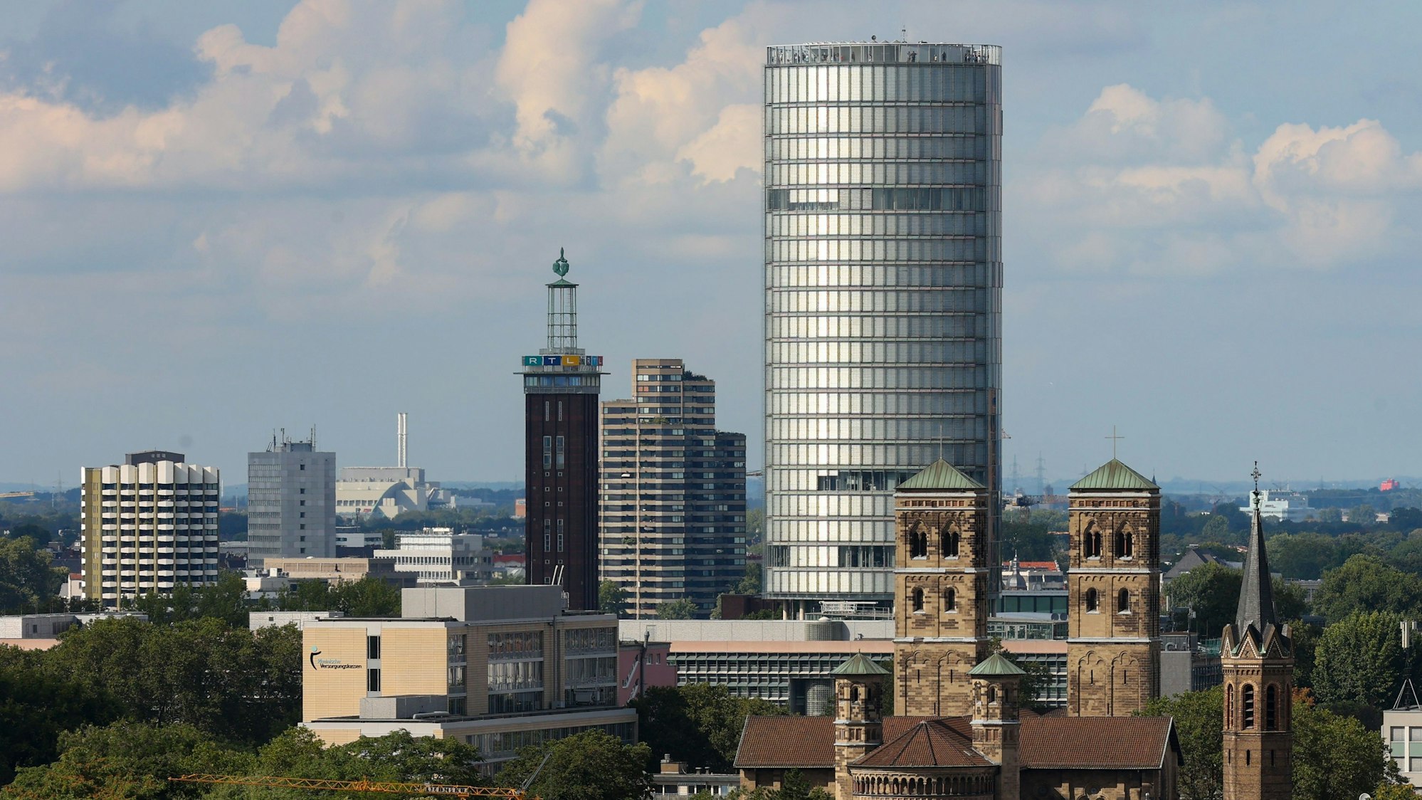 Der LVR-Turm (KölnTriangle) mit der Kirche St. Heribert davor.