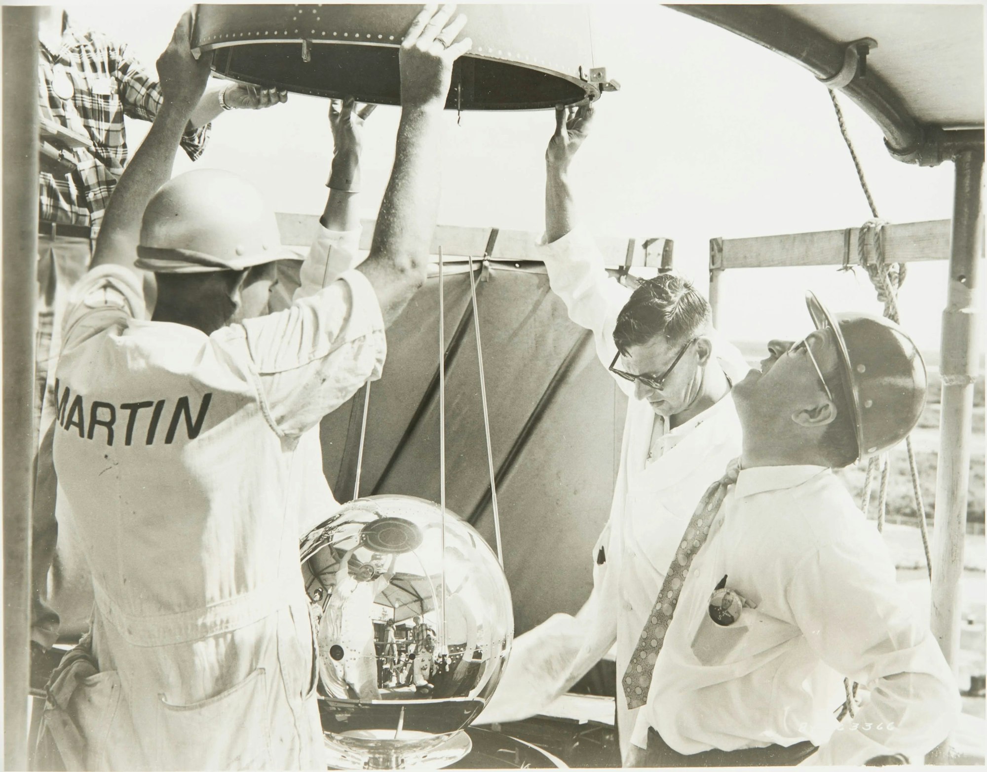 Der kugelförmige Vanguard-II-Satellit spiegelt die Szene auf diesem Foto aus dem Jahr 1959 wider, das die Vorbereitungen für seinen Start zeigt.