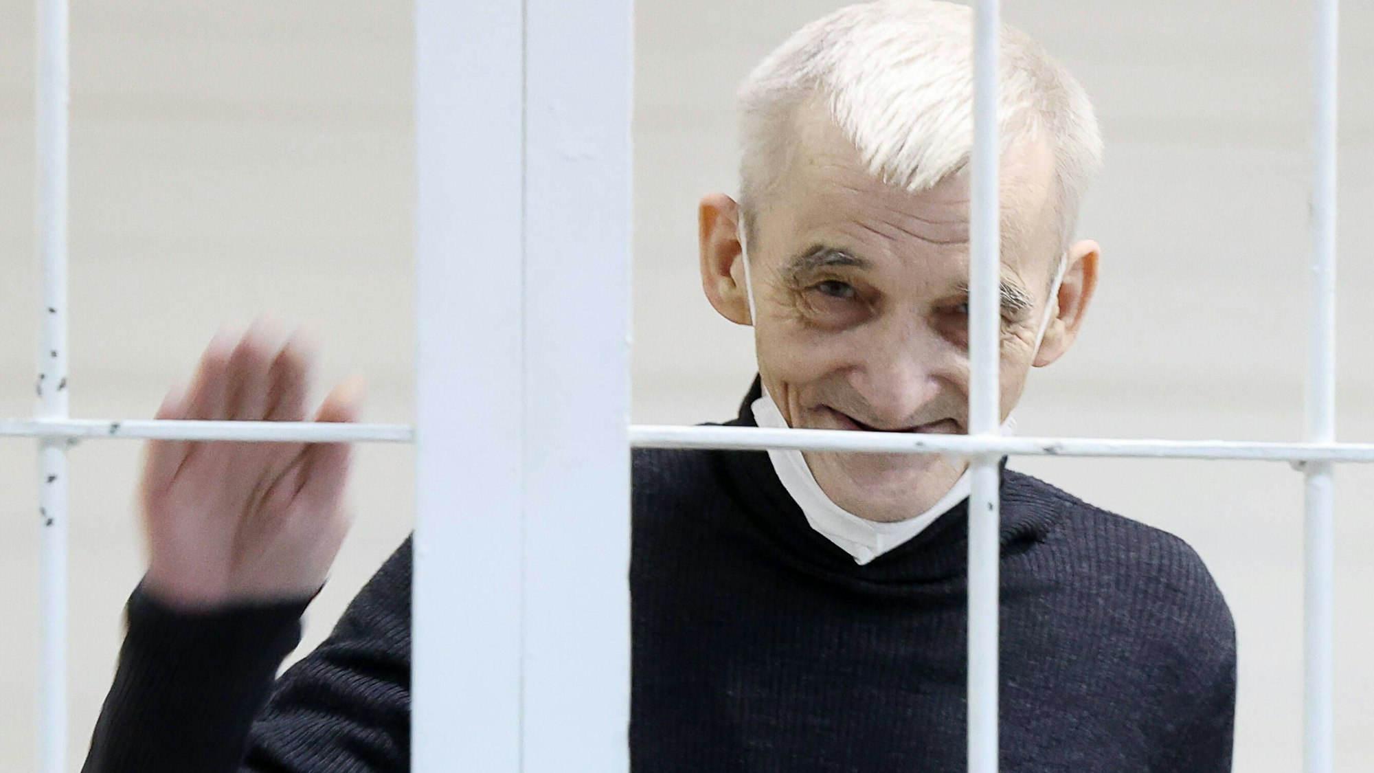 Juri Dmitrijew winkt aus seiner Zelle.