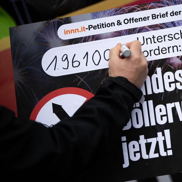 Eine Hand unterschreibt auf einem Plakat zum Böllerverbot.