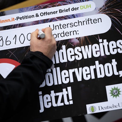 Eine Hand unterschreibt auf einem Plakat zum Böllerverbot.