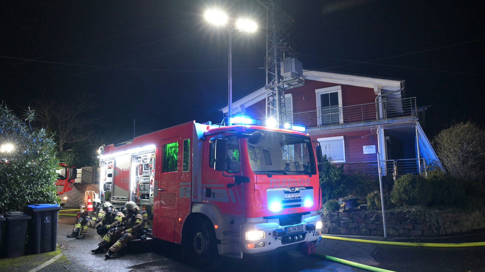 Ein Feuerwehrfahrzeug steht in Bergisch Gladbach-Voislöhe mit Blaulicht.