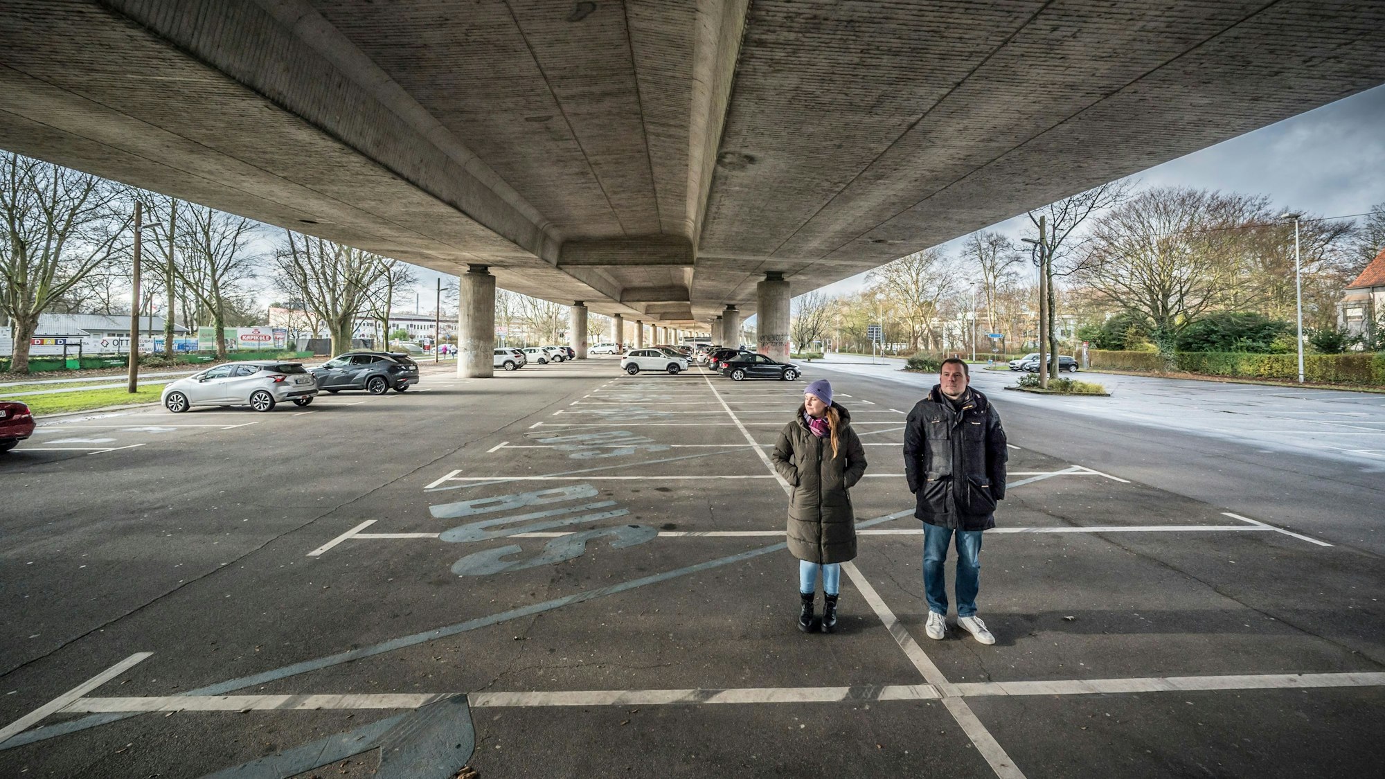 Ina Hamm und Moritz Tamm stehen auf dem Parkplatz unter der Stelze.