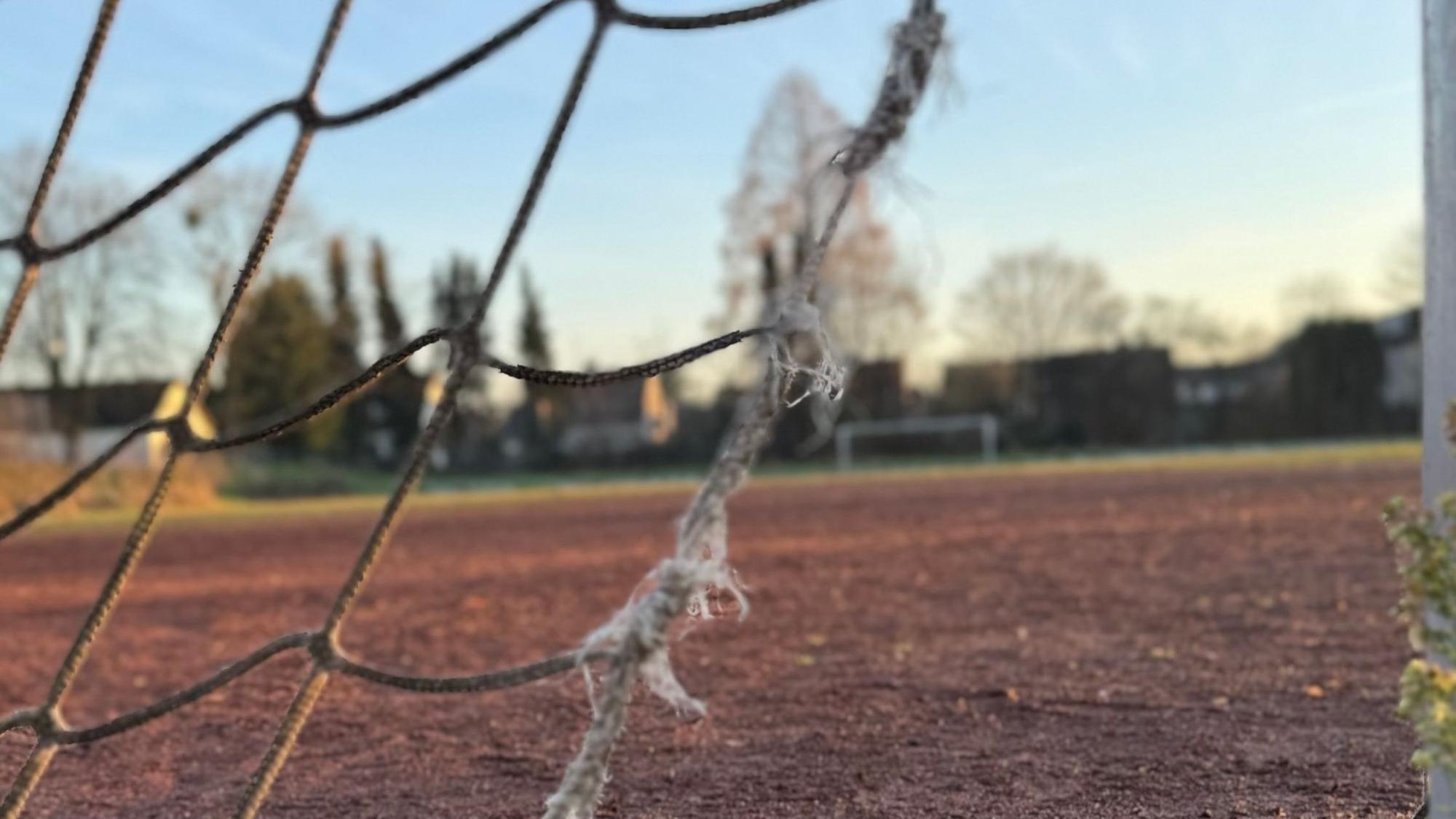 Eine Aschenplatz mit einem zerrissenen Tornetz im Vordergrund