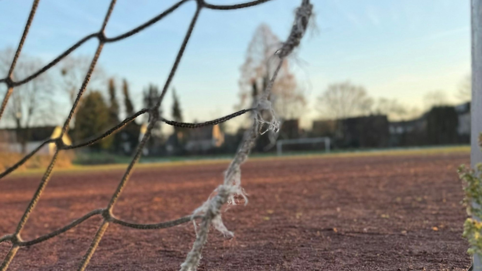 Eine Aschenplatz mit einem zerrissenen Tornetz im Vordergrund