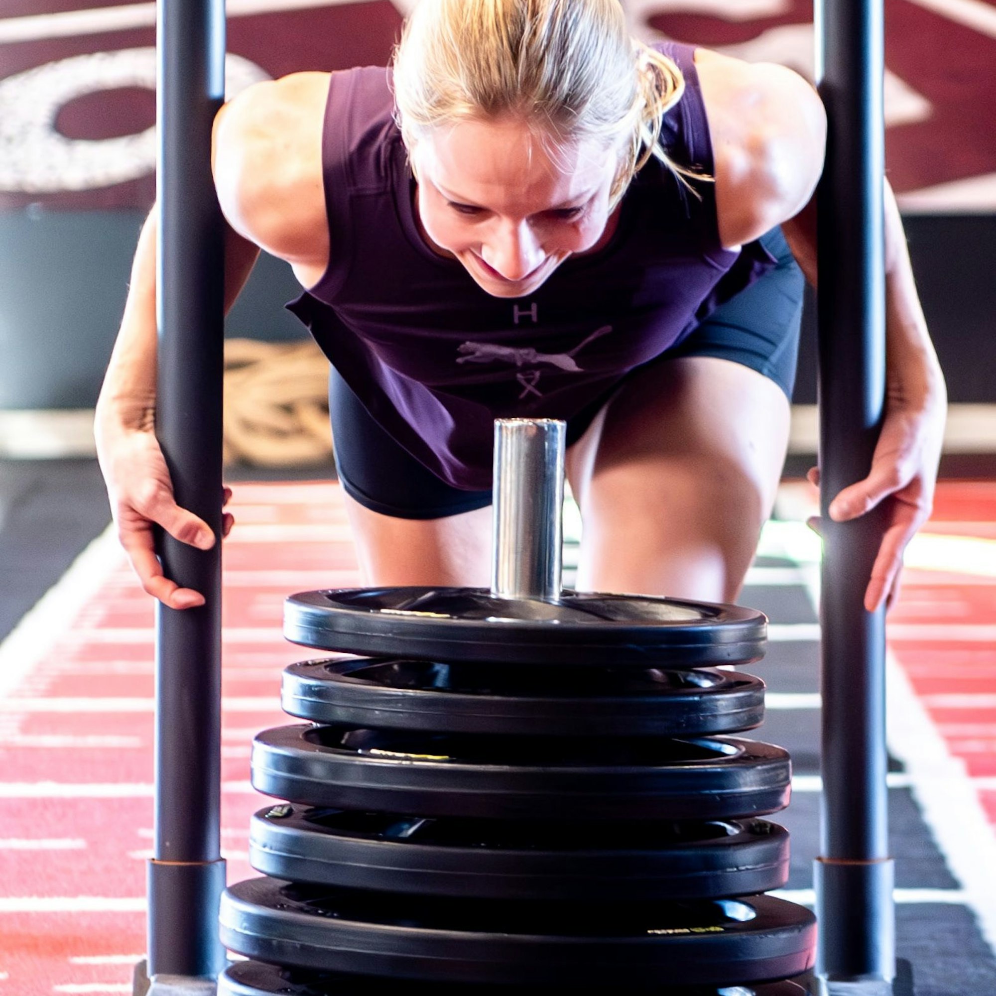 Nina Koep schiebt einen mit Gewichten beladenen Schlitten.