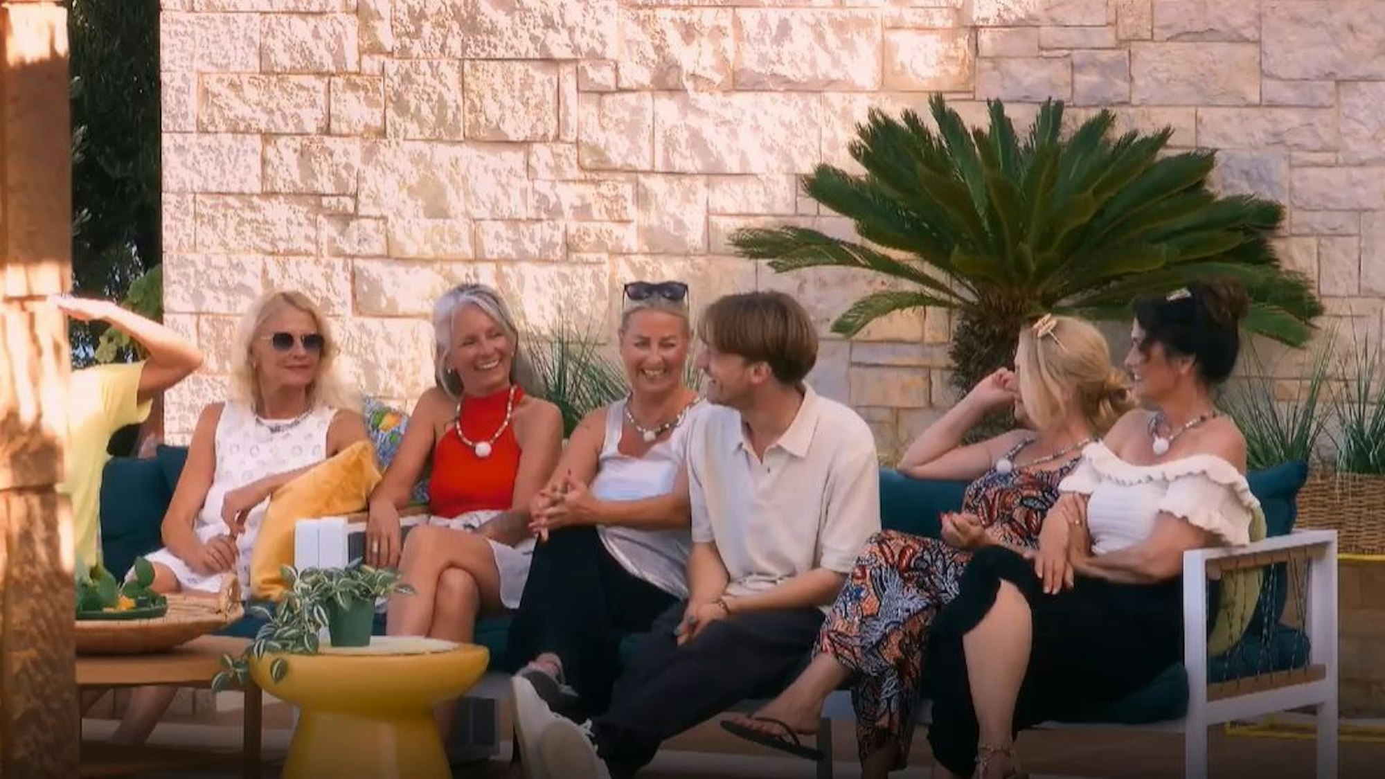 Yanek (dritter v. rechts) sitzt mit den „Golden Bachelor“-Kandidatinnen auf einem Sofa. Die Stimmung ist gut, geht man von den Gesichtern der Frauen aus.