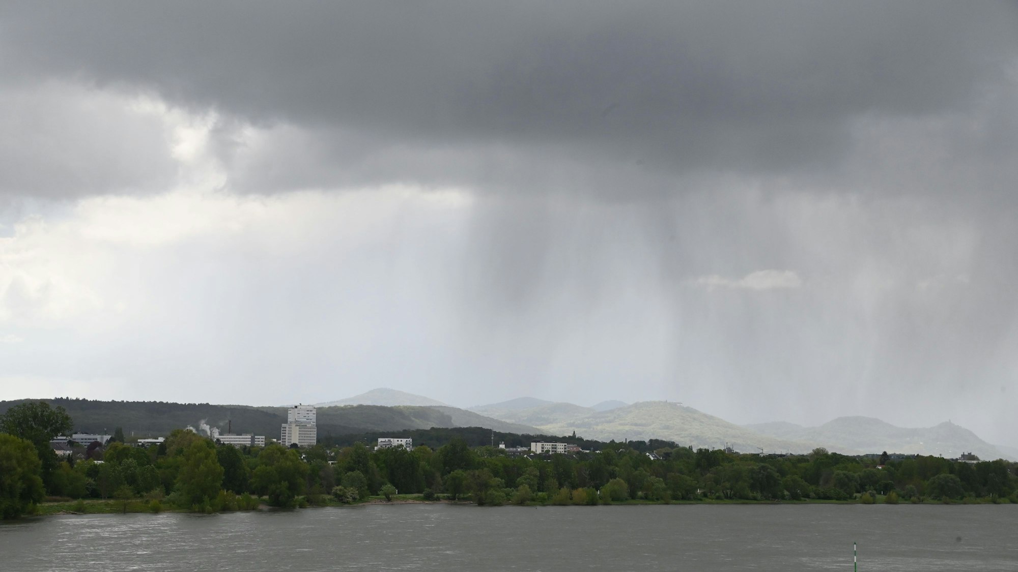 Regenwolken über Bonn Beuel im Hintergrund das sonnige Siebengebirge.