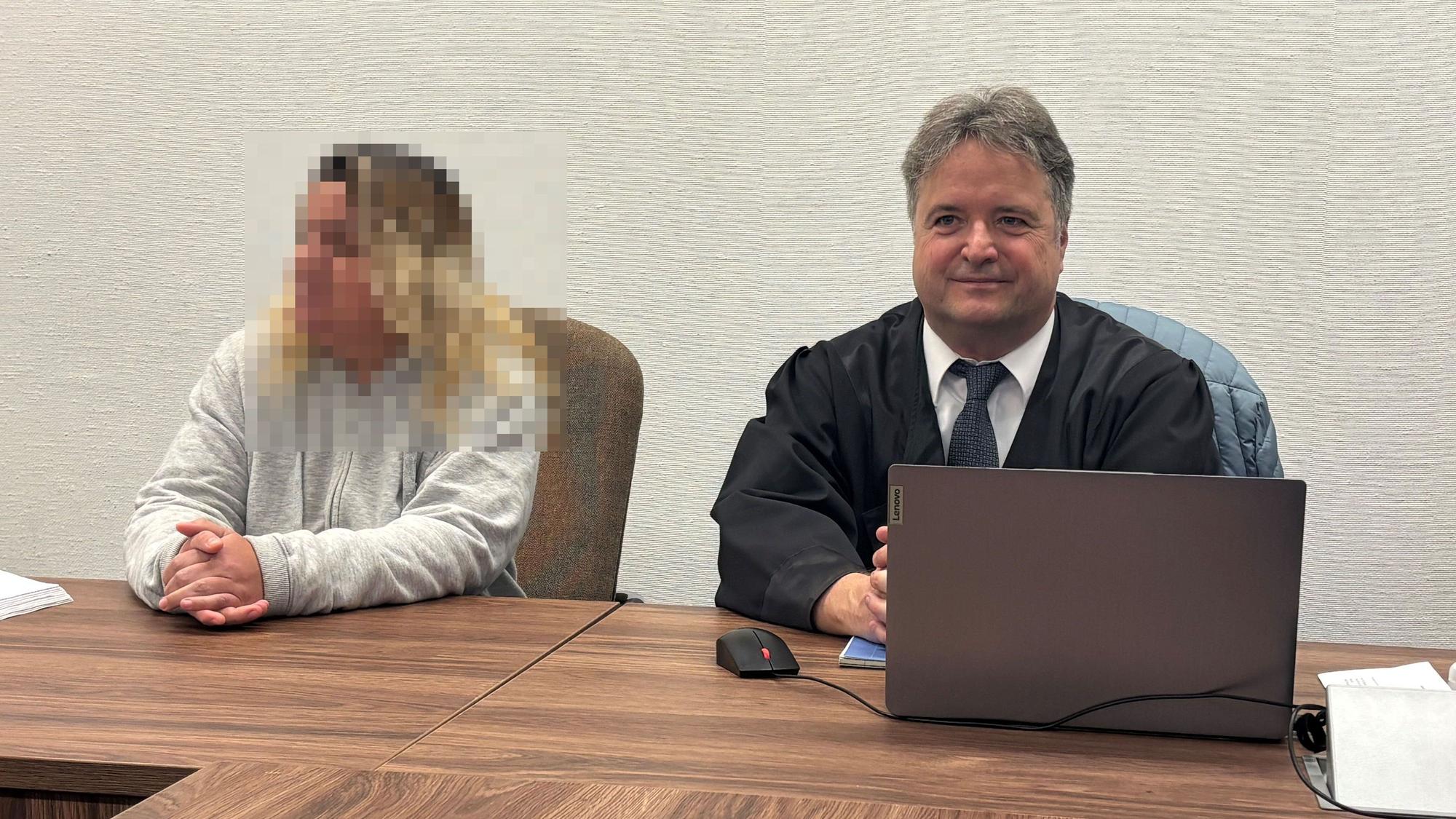 Eine Angeklagte sitzt mit ihrem Verteidiger in einem Gerichtssaal.