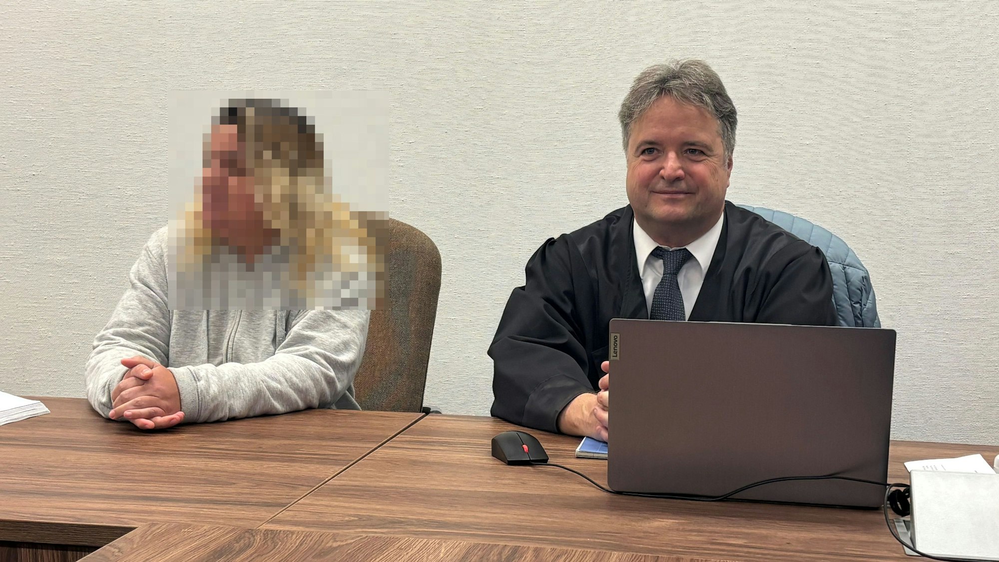 Eine Angeklagte sitzt mit ihrem Verteidiger in einem Gerichtssaal.