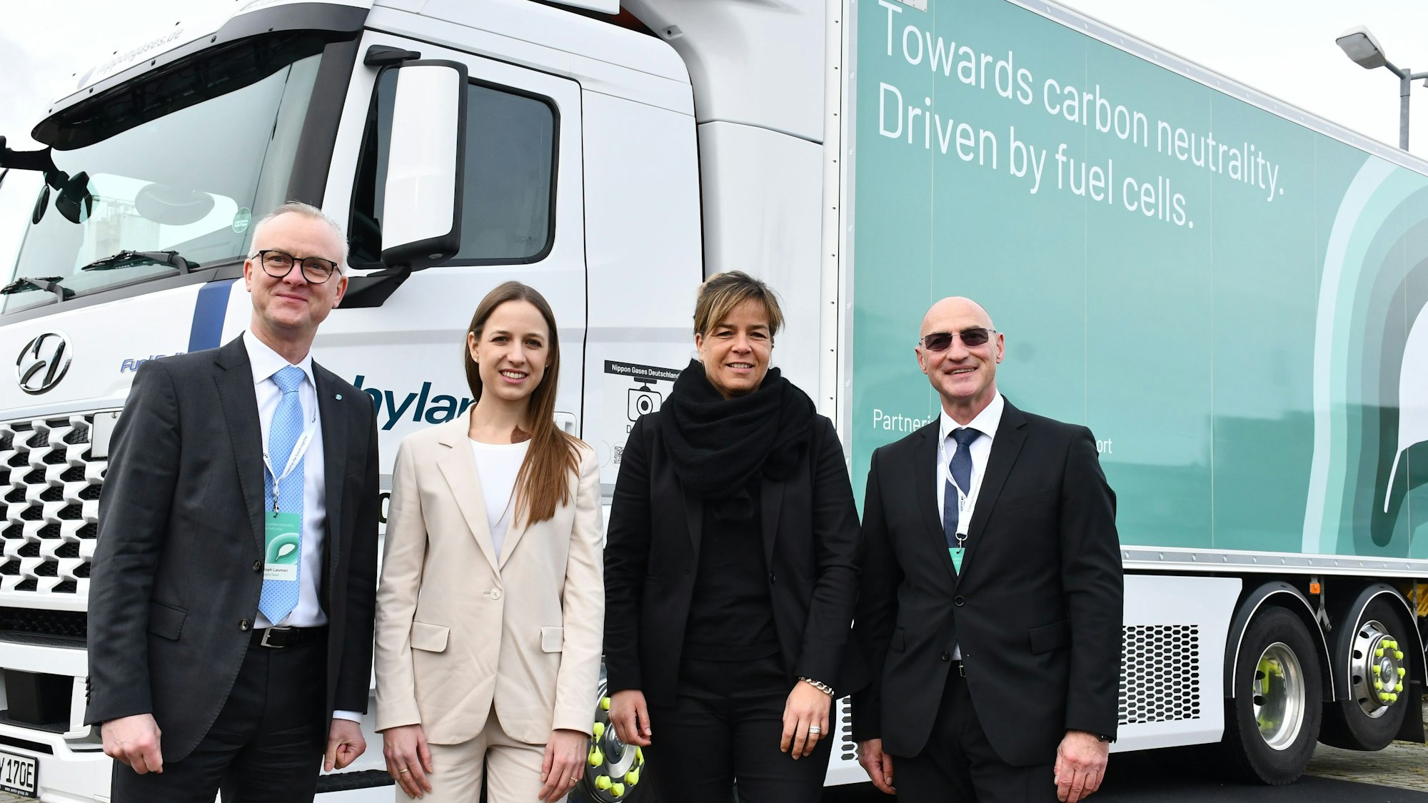 Das Foto zeigt die Ministerin und Unternehmensvertreter vor dem Lastwagen, der mit Wasserstoff betrieben wird.