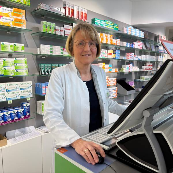 Eine Apothekerin hinter ihrer Kasse.