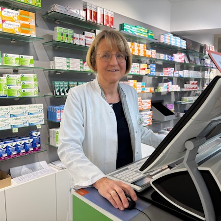 Eine Apothekerin hinter ihrer Kasse.