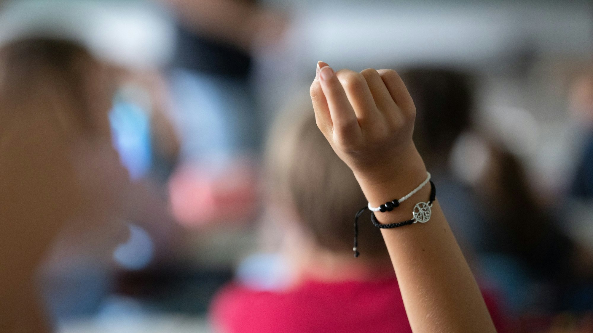 Eine Schülerin zeigt im Unterricht auf.