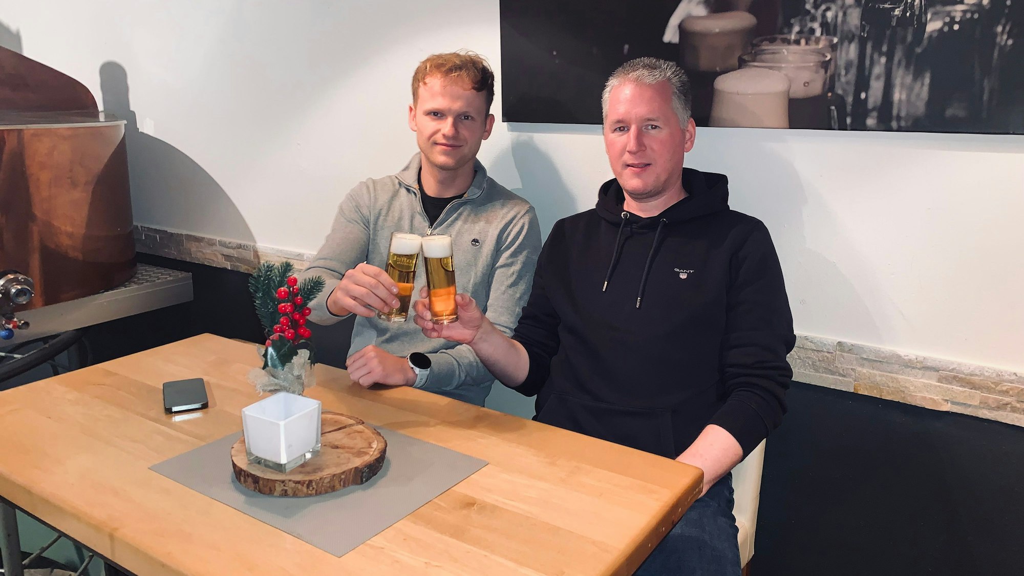 Zwei Männer stoßen mit Bier an.