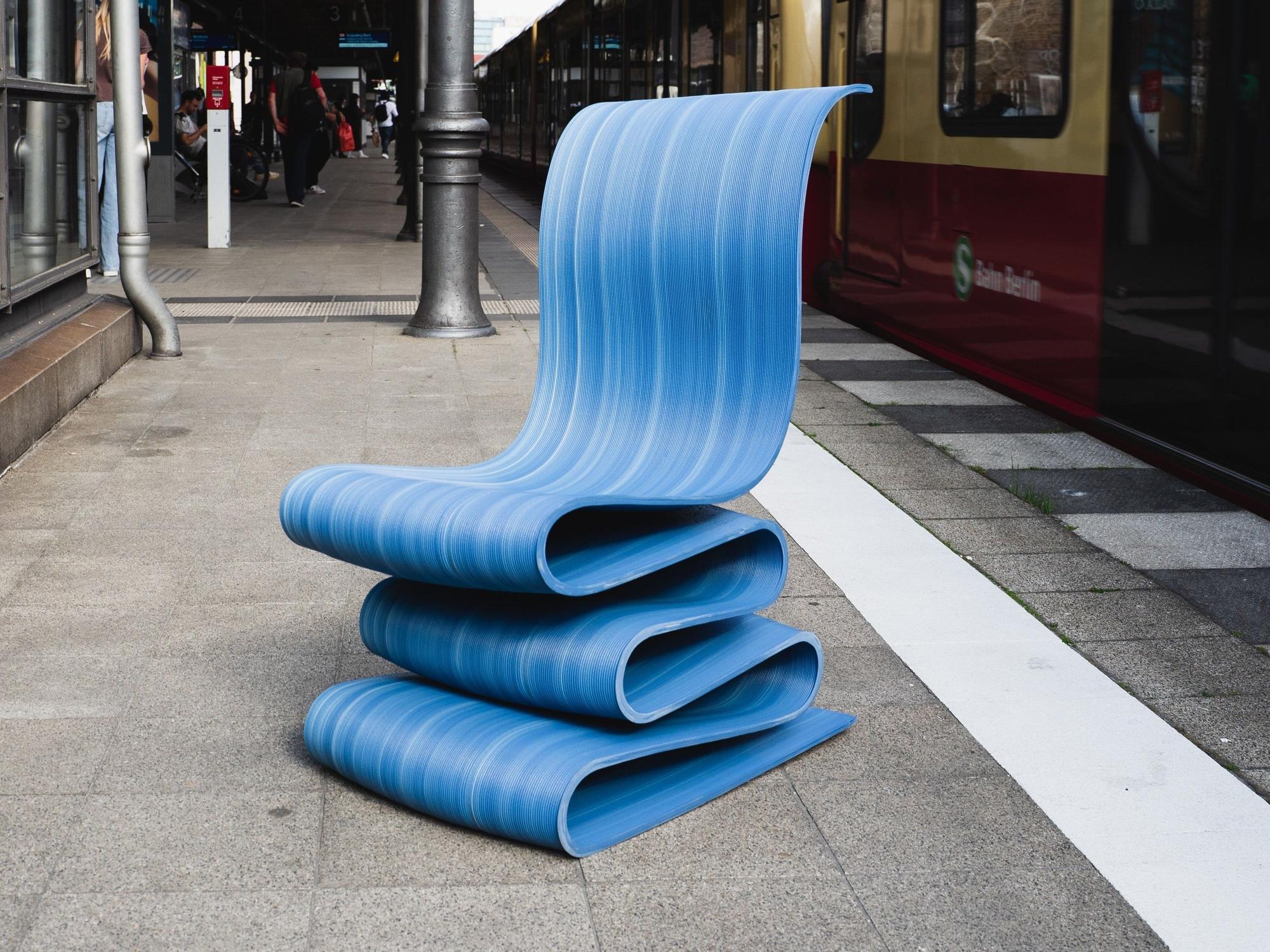 Blauer Stuhl aus dem 3D-Drucker, der aus recyceltem Plastik besteht.