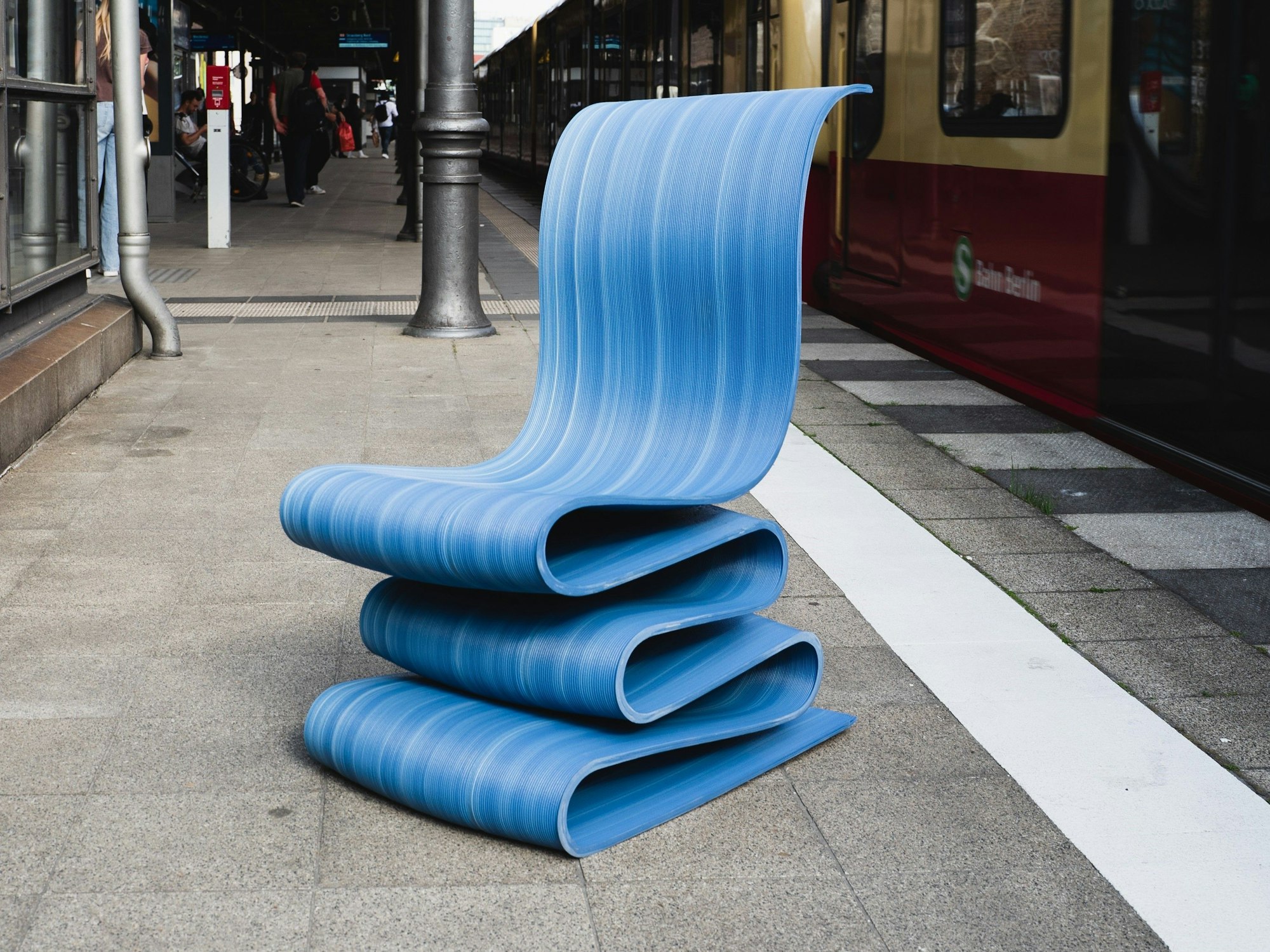 Blauer Stuhl aus dem 3D-Drucker, der aus recyceltem Plastik besteht.