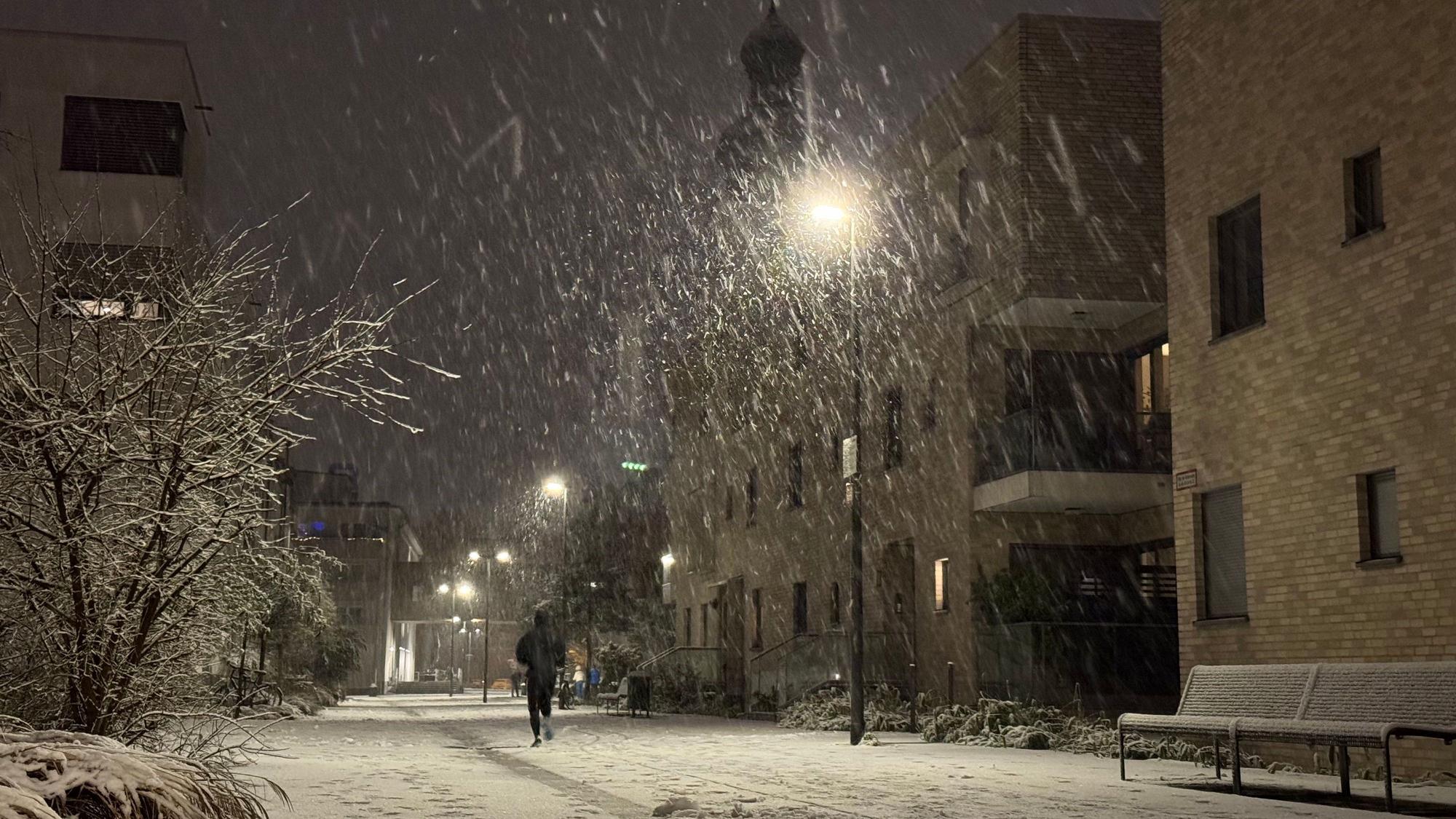 08.01.2025, Köln: Vom Schnee bedeckt sind die Straßen im Ortsteil Sülz auf dem Gelände des ehemaligen Kinderheimes mit der Kirche "Zur heiligen Familie". Am Abend hat es in der Stadt begonnen, zu schneien. Foto: Matthias Heinekamp