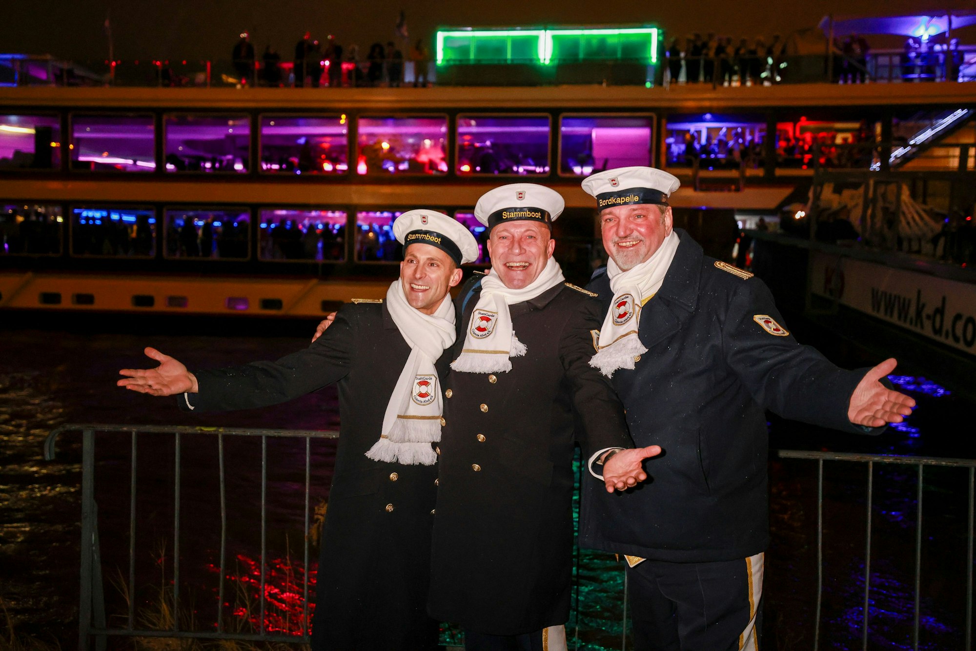 René Klöver, Michael Samm und Hendrik Ermen posieren vor einem Schiff am Rhein.