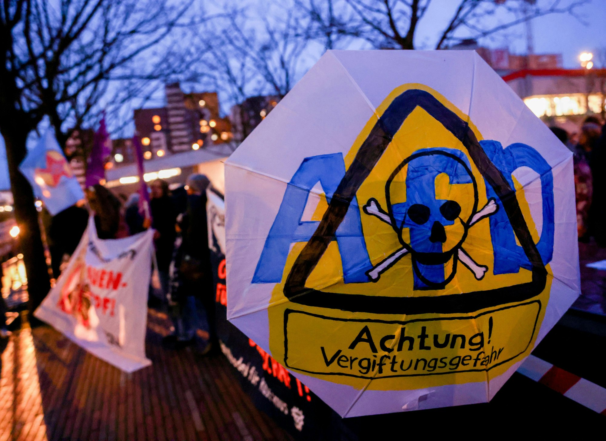 Regenschirm auf dem „AfD - Achtung Vergiftungsgefahr“ steht.