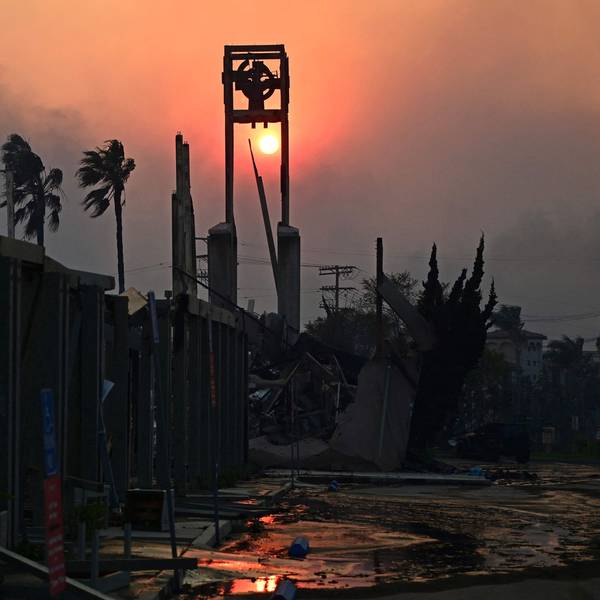 The sun is seen through smoke behind the ruins of the Pacific Palisades Presbyterian Church after the passage of the Palisades Fire in Pacific Palisades, California, on January 8, 2025. At least five people have been killed in wildfires rampaging around Los Angeles, officials said on January 8, with firefighters overwhelmed by the speed and ferocity of multiple blazes. (Photo by AGUSTIN PAULLIER / AFP)