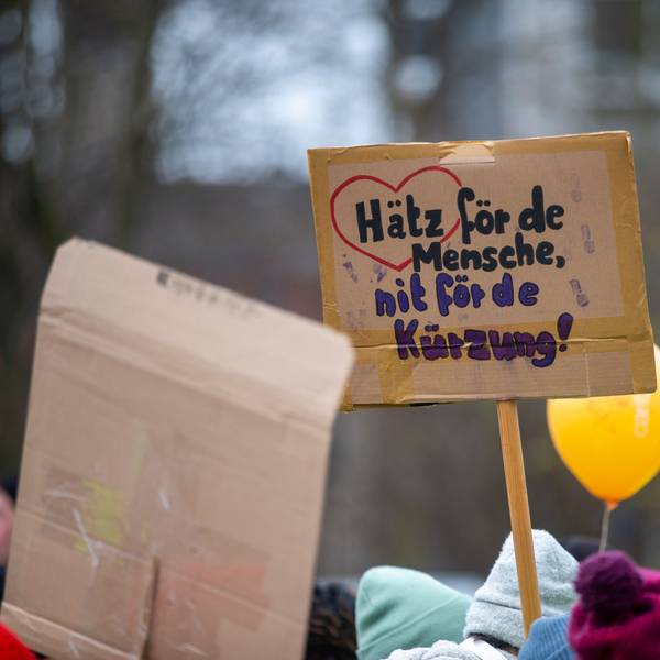 Bei einer Großdemonstration der Wohlfahrtsverbände in Köln gegen die geplanten Haushaltskürzungen hält eine Teilnehmerin ein Schild hoch mit der Aufschrift: „Hätz för de Mensche, nit fö de Kürzung“.