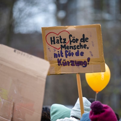 Bei einer Großdemonstration der Wohlfahrtsverbände in Köln gegen die geplanten Haushaltskürzungen hält eine Teilnehmerin ein Schild hoch mit der Aufschrift: „Hätz för de Mensche, nit fö de Kürzung“.