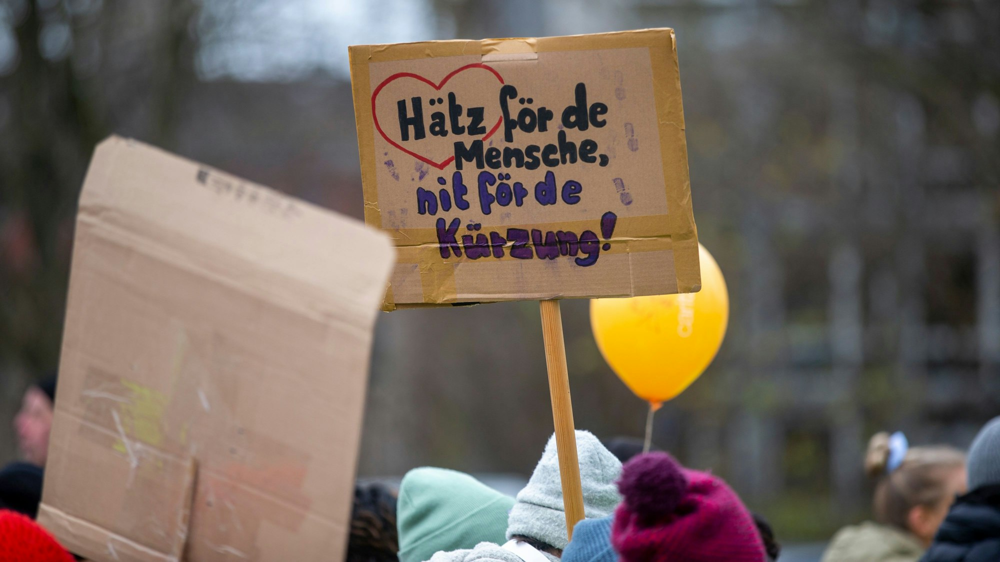 Bei einer Großdemonstration der Wohlfahrtsverbände in Köln gegen die geplanten Haushaltskürzungen hält eine Teilnehmerin ein Schild hoch mit der Aufschrift: „Hätz för de Mensche, nit fö de Kürzung“.